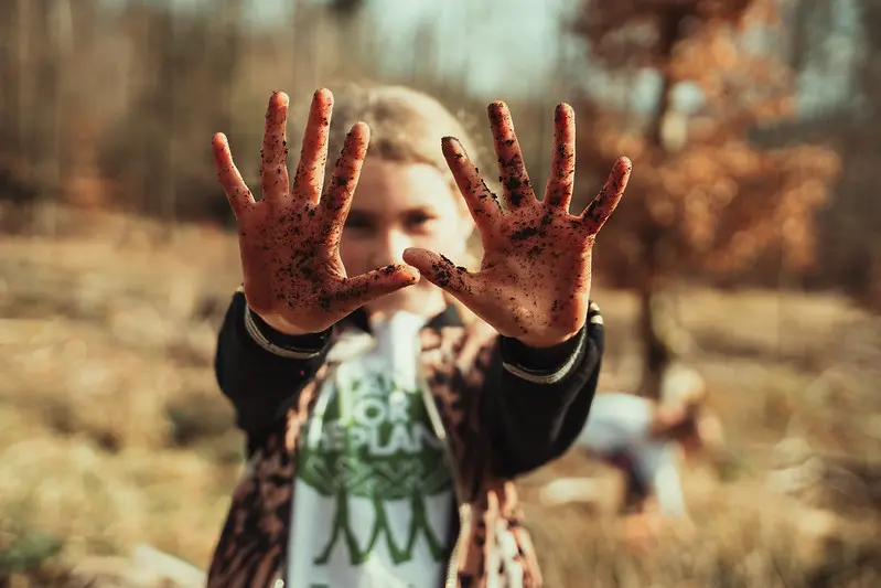 Ambassador showing muddy hands after planting by Plant-for-the-Planet.