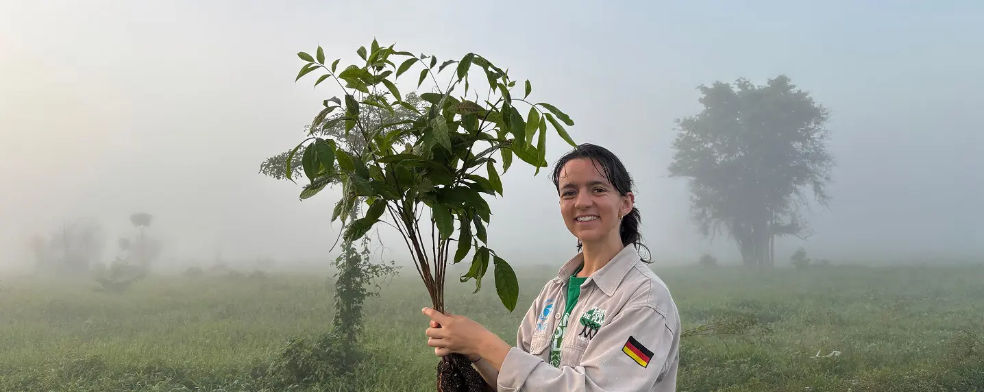 Anna Gee holding a Plant by Plant-for-the-Planet