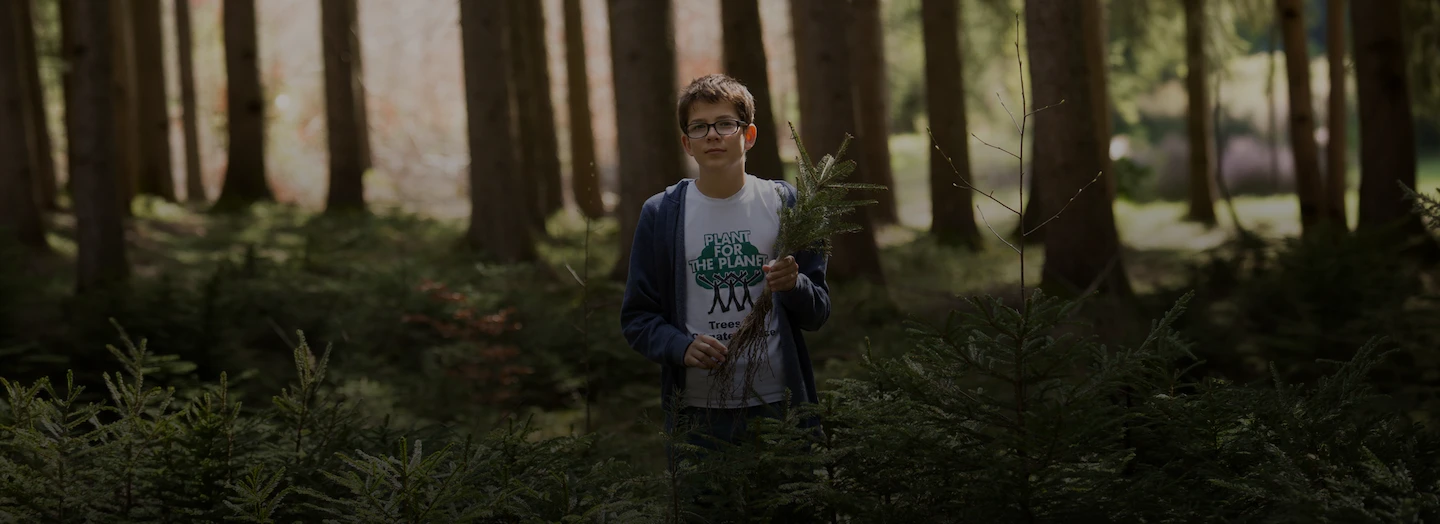 Young Felix holding a Plant by Plant-for-the-Planet